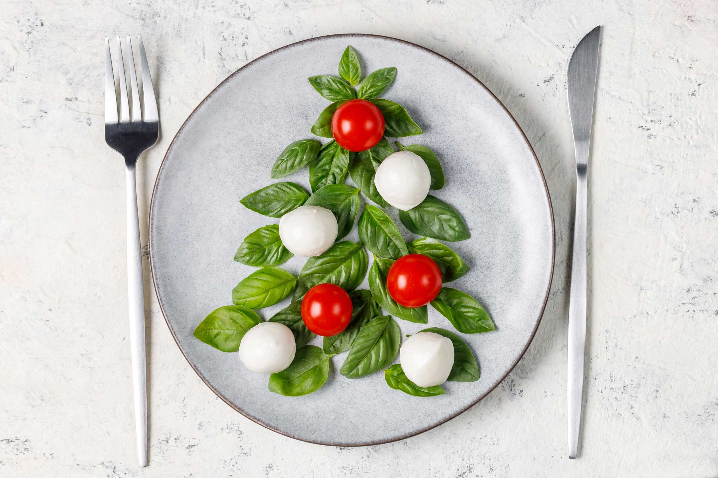 Christmas tree made of basil leaves on a plate setting