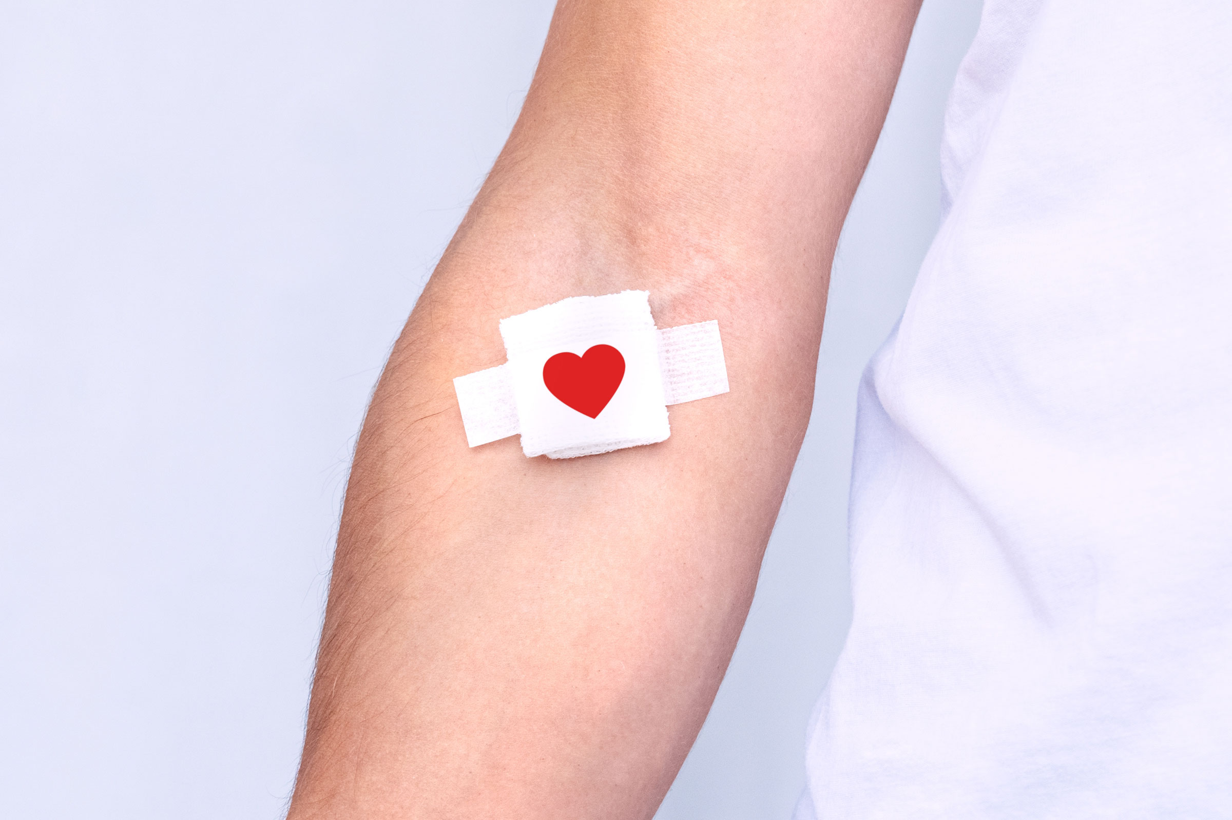 Arm with a heart bandage after blood donation