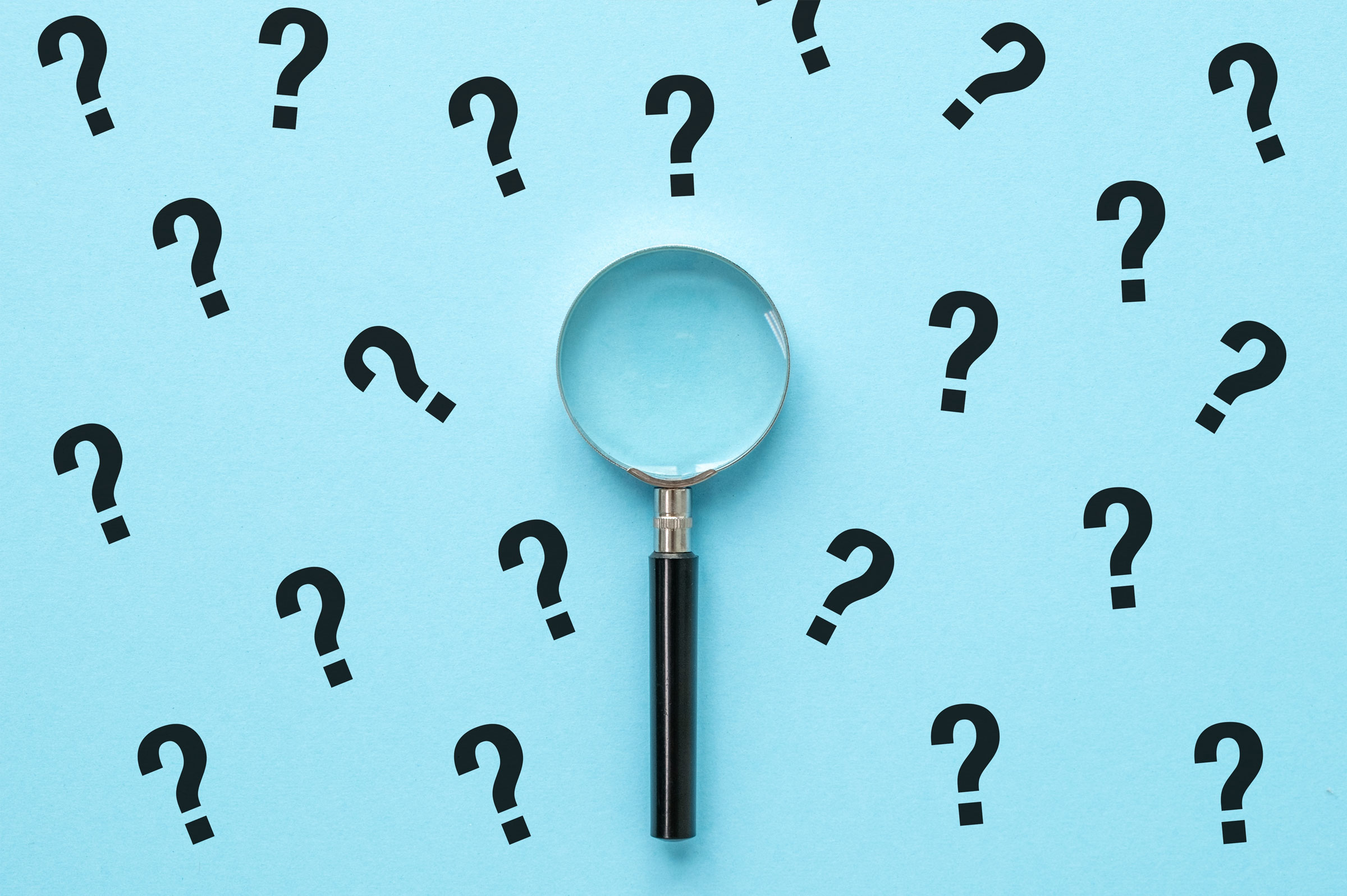 magnifying glass with question marks on a blue backdrop