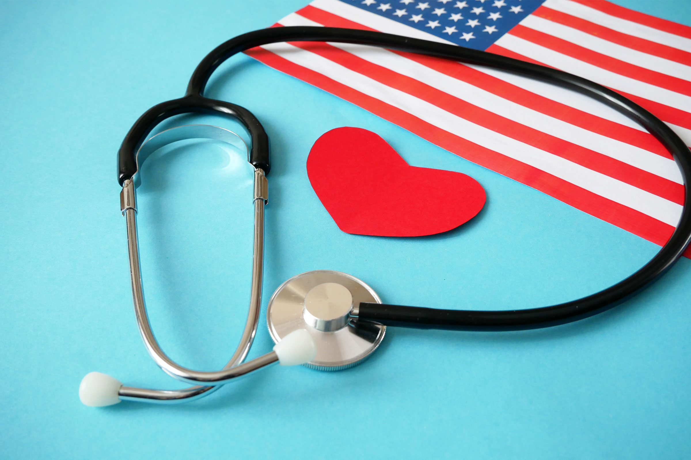 American flag with heart and stethoscope, blue background