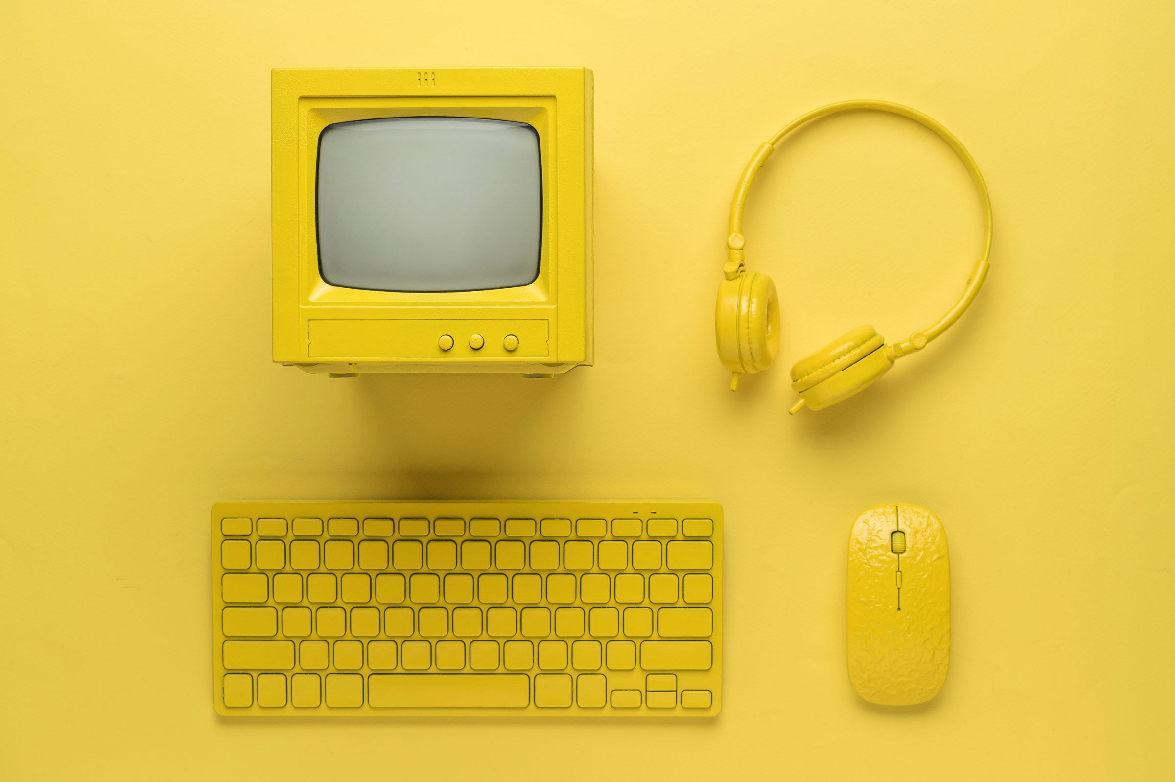 yellow background with yellow computer, headphones, keyboard, and mouse